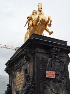 Goldener Reiter mit Schild "Mehr Vasektomie wagen"